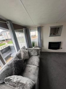 a living room with a couch and a television at 16 orchid meadows in Ashington