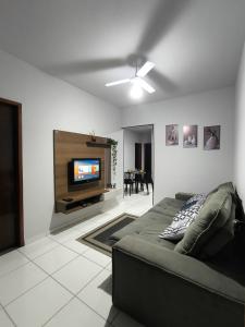 Una sala de estar con un sofá y un televisor de pantalla plana. en Brisa do Sul, en Umuarama