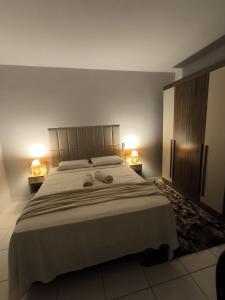 Un dormitorio con una cama grande con dos toallas encima. en Brisa do Sul, en Umuarama