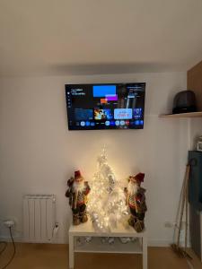 科洛布里埃Studio Vars的桌子上摆着一棵白色圣诞树和两个圣诞老人。