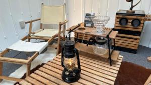 a room with a table with a lamp and a chair at Kuruma Asobi Adventure Field Appi - Camp - Vacation STAY 42095v in Hachimantai