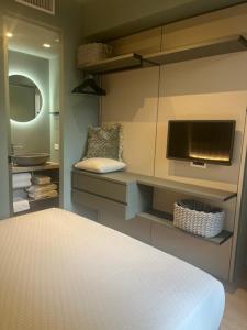 里乔内RICCIONE SUITE DESIGN的一间卧室配有一张床、一台电视和一面镜子 更多34张照片