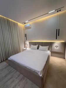 een slaapkamer met een groot bed met witte lakens bij Altair in Simkent +8 foto's