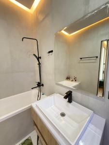 een witte badkamer met een wastafel en een spiegel bij Altair in Simkent