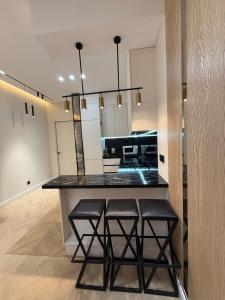 een keuken met een aanrecht met twee krukken bij Altair in Simkent
