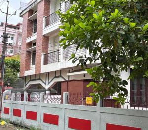 ein Gebäude mit einem weißen Zaun und einem Gebäude in der Unterkunft SPOT ON Sanskrit Guest House in Dispur