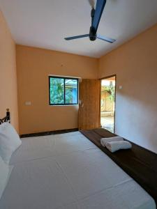 a bedroom with a large bed and a window at Halfway Home Hilltop in Gokarna