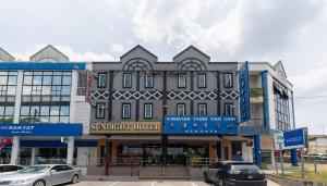 a large building with cars parked in front of it at Sunlight Hotel Kulai in Kulai