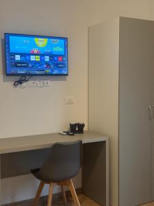 a desk with a chair and a television on a wall at Dormi e Vai in Citta' Sant'Angelo +12 photos