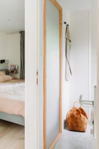 una camera da letto con specchio accanto a un letto di Boshuisje Lou op de Veluwe a Hattemerbroek