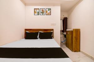 a bedroom with a white bed with black pillows at SPOT ON Night Owl Hotel &guest House in Bārāsat