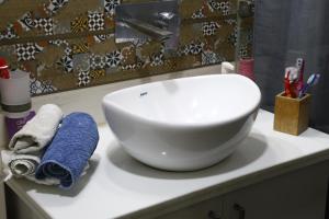 a white sink sitting on top of a bathroom counter at Entire Vintage Apartment, Historic Heights Haven in Noida +25 photos