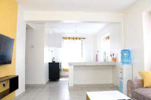 een woonkamer met een bank en een keuken bij Willary Heights Apartment in Bungoma +6 foto's