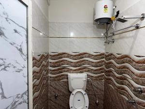 a bathroom with a toilet and a wall at Hotel O Silk Premium in Khagaul