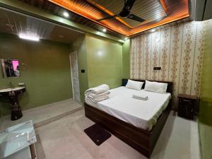 a bedroom with a bed and a bathroom with a sink at Hotel O Silk Premium in Khagaul