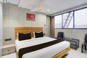 una camera da letto con un letto e due sedie di Hotel O by OYO Olive7 a Surat