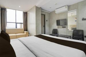 una camera d'albergo con un letto e un soggiorno di Hotel O by OYO Olive7 a Surat