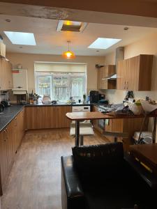 a large kitchen with wooden cabinets and a table at spacious King bed 30FT Room in Kenton