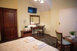 a room with a bed and a desk and a mirror at Hotel Mateo in Stopnica