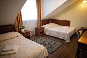 a hotel room with two beds and a window at Hotel Mateo in Stopnica