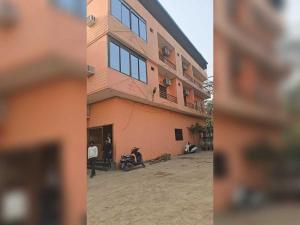 Un edificio con una motocicleta estacionada enfrente. en Hotel O Shree Paying Guest House, en Rāmnagar