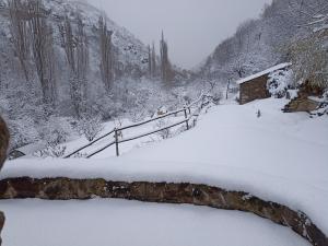 un camino cubierto de nieve frente a una cabaña en Ecogite du Mas de Trape, en Talau