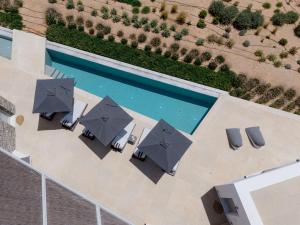 an overhead view of a pool with umbrellas and chairs at Aegean Hestia Luxury Villa of Paros in Kampos Paros