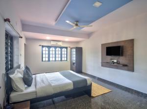 una camera da letto con un letto e una TV a schermo piatto di Hotel Beach Edge a Calangute