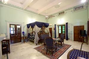 The Hari Mahal-A Luxury Heritage Suit Jaipur City Centre في جايبور: غرفة معيشة بها سرير وطاولة وكراسي