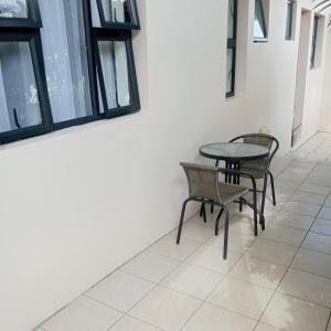 a table and chairs in a room with windows at Rephidim Palace 02 in Durban