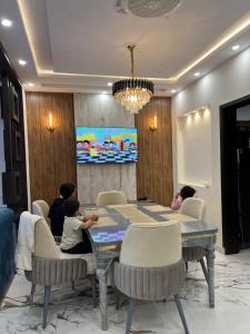 a group of people sitting around a table in a room at Brand New Vacation House in Lahore