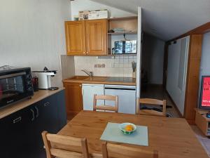 Les Contamines Montjoie في Le Cugnon: مطبخ مع طاولة خشبية مع وعاء من الفواكه عليه +9 صور