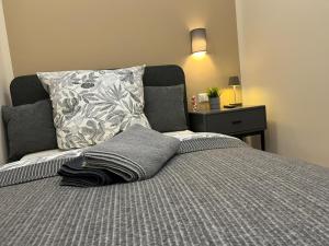 a bed with a gray blanket and a pillow at Live-In Room 6 - Klimatisiert - Coffee for free - in Karlsruhe