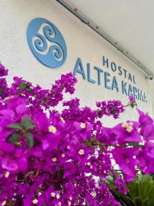 阿尔啼Hostal Altea Karma的爱丽丝·卡玛医院的标志牌上开着紫色的花