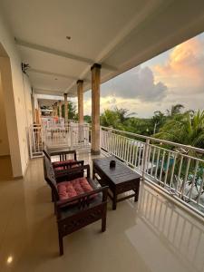 a balcony with two chairs and a table on it at Azona Greens Uluwatu in Uluwatu