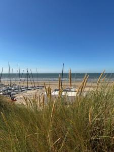 a beach with boats sitting in the sand at Cozy Beach Home in De Haan