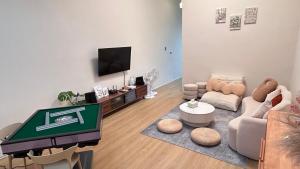 a living room with a couch and a tv at Wumu B&B in Hengchun South Gate