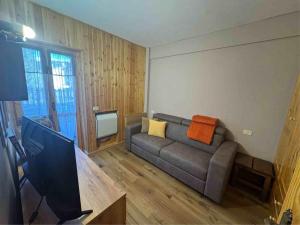 een woonkamer met een bank en een flatscreen-tv bij Piccola Marmotta in Ovindoli