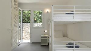 a bedroom with white bunk beds and a desk at Villa Sand and Sea in Pelekas