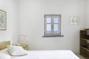 a white bedroom with a window on the wall at Villa Sparta in Otzias +25 photos