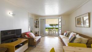 un soggiorno con un divano e una televisione di Villa Marina a Pelekas