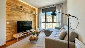 a living room with a couch and a television at Molina Molinísimo in La Molina