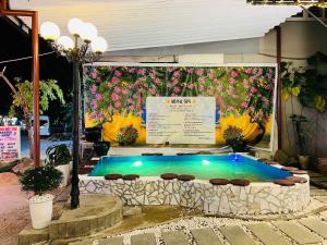 a swimming pool in front of a building with flowers at Royal Hotel & Spa Hoi An in Hoi An