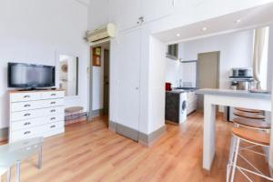 eine Küche mit weißen Wänden, Holzböden und einem Tisch in der Unterkunft Studio élégant pour 4 personnes, à quelques pas de la Croisette in Cannes