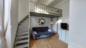 ein Wohnzimmer mit einem Sofa und einem Hochbett in der Unterkunft Studio élégant pour 4 personnes, à quelques pas de la Croisette in Cannes