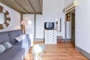 ein Wohnzimmer mit Sofa und Fernseher in der Unterkunft Studio élégant pour 4 personnes, à quelques pas de la Croisette in Cannes