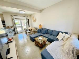 Una sala de estar con un sofá azul y una mesa. en Zephyr House 3BR Pool, Rooftop & Ocean View, en Grand Gaube