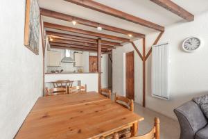 Appartement Ski, Au Pied Des Pistes في لا مونجي: مطبخ وغرفة طعام مع طاولة خشبية