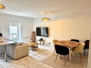 a living room with a table and chairs and a tv at Appartement cocooning in Laval