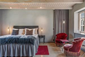 una camera da letto con un letto e una sedia rossa di Mellby Atelier på Österlen a Kivik